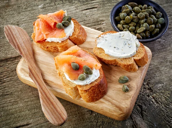 Rebanadas de pan tostado con queso crema y salmón ahumado —  Fotos de Stock