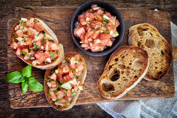 Ingredientes bruschettas en tabla de cortar de madera —  Fotos de Stock