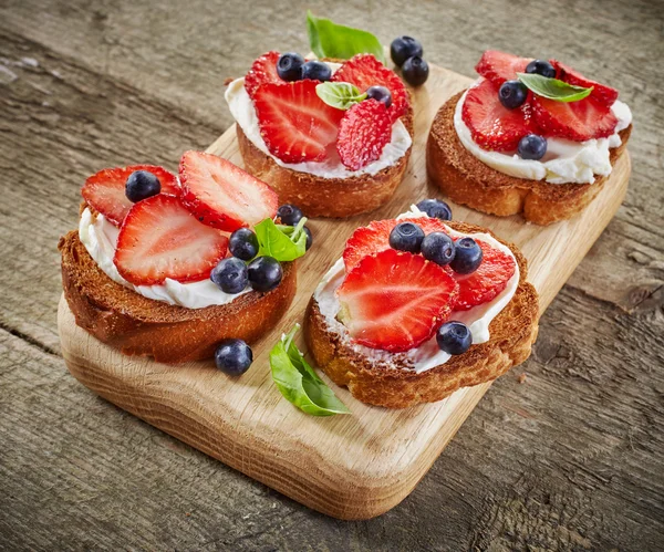 Toasted bread with berries and cream cheese — Stock Photo, Image