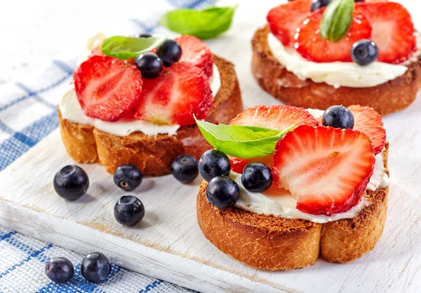 Toasted bread with cream cheese and berries — Stock Photo, Image