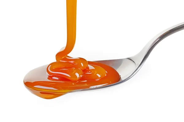 Spoon of caramel sauce — Stock Photo, Image