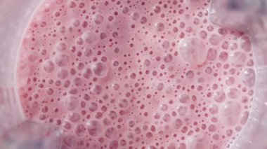 Çilekli ve muzlu, pembe milkshake karışımı. Üst Manzara. Ağır çekim. Sağlıklı protein smoothie içecek konsepti, yiyecek yakın çekim