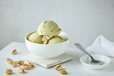 bowl of pistachio ice cream on white table background