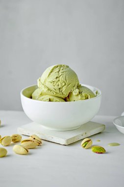 bowl of pistachio ice cream on white table background