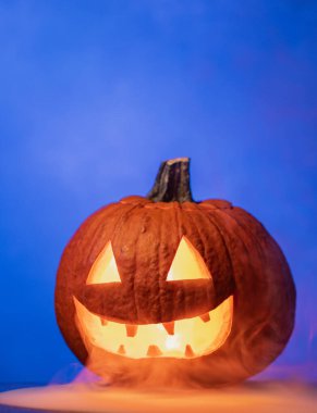 Ürkütücü Cadılar Bayramı Balkabağı Parlayan Kırmızı Gözler ve Mavi Fonda Duman