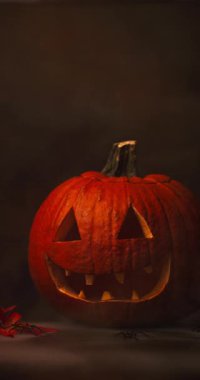 Siyah arka planda parlayan kırmızı gözlü ve dumanlı ürkütücü Cadılar Bayramı Balkabağı