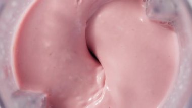 Çilekli ve muzlu, pembe milkshake karışımı. Üst Manzara. Ağır çekim. Sağlıklı protein smoothie içecek konsepti, yiyecek yakın çekim