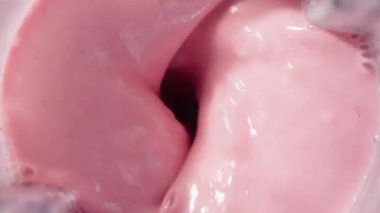 Çilekli ve muzlu, pembe milkshake karışımı. Üst Manzara. Ağır çekim. Sağlıklı protein smoothie içecek konsepti, yiyecek yakın çekim