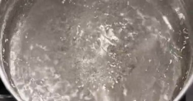 Kaynayan su dokusu elektrikli sobanın üstüne yakın çekim, yiyecekler üst manzaraya yakın.