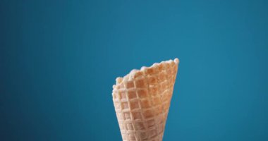 Boş dondurma waffle külahı mavi arkaplanda dönüyor