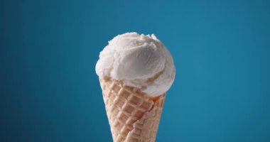 Waffle külahında vanilyalı dondurma, mavi arkaplanı açıyor.