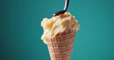 Çikolata sosu sarı mango ve waffle külahında ananas şerbeti üzerine akar. Renkli arka planda açılır, yemek yakın planda kalır.