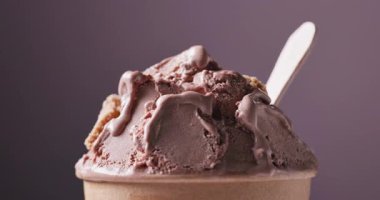 Çikolata ve fıstık dondurması kağıt bardakta dönüyor, yemekler mor arka planda kapanıyor.