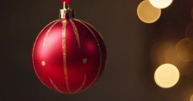 Kırmızı parlak Noel topu ve arka planda bulanık ışıklar