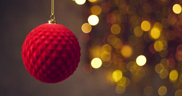elegant red Christmas ball rotating on blurred lights background elegant red Christmas ball rotating on blurred lights background