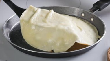Aşçı kızartma tavasında krep çevirir. Mutfaktaki sıcak tavada taze pişmiş krep yakın plan. Sağlıklı kahvaltı için evde leziz krep yapma süreci, yiyecek kapanıyor.