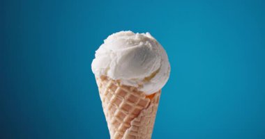 Waffle külahında vanilyalı dondurma, mavi arkaplanı açıyor.