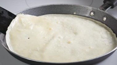 Aşçı kızartma tavasında krep çevirir. Mutfaktaki sıcak tavada taze pişmiş krep yakın plan. Sağlıklı kahvaltı için evde leziz krep yapma süreci, yiyecek kapanıyor.