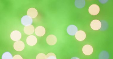 Yeşil şenlik arka planında parıldayan altın gibi parlak noel ışıkları