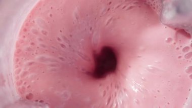 Çilekli ve muzlu, pembe milkshake karışımı. Üst Manzara. Ağır çekim. Sağlıklı protein smoothie içecek konsepti, yiyecek yakın çekim