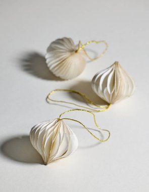 Açık gri arkaplan üzerine beyaz kağıt Noel süsleri, seçici odak