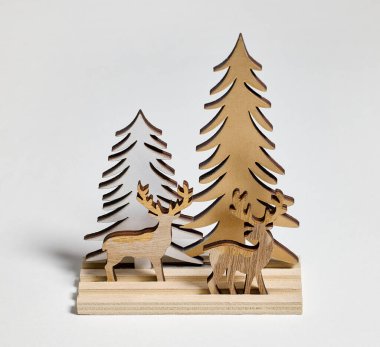 Tahta Noel dekorasyonu geyikleri ve açık gri arka planda ağaçlar