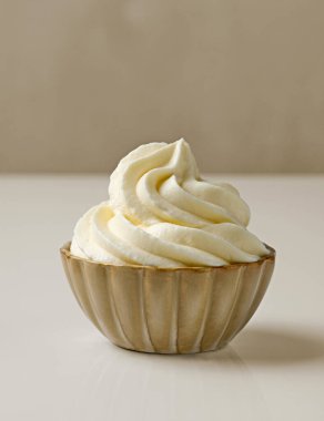 Bej arka planda bir kase krema.