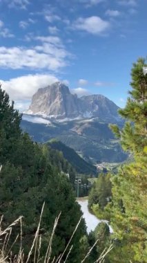 İtalya 'nın Dolomitler şehrinde yaz sezonu boyunca alp arazisinde hareket eden kablo araba. Yeşil ormanları, vadileri, kayalık tepeleri ve açık mavi gökyüzü olan manzaralı dağ manzarası.