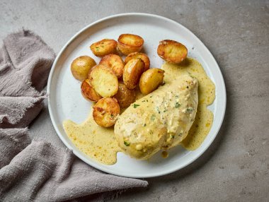 Bir tabak kızarmış patates ve kremalı köri soslu leziz tavuk göğsü mükemmel bir öğle yemeği için hazır.