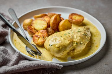 Bir tabak kızarmış patates ve kremalı köri soslu leziz tavuk göğsü mükemmel bir öğle yemeği için hazır.