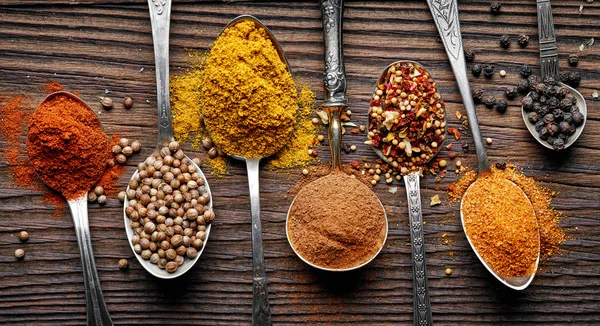 Various spices in silver spoons — Stock Photo, Image