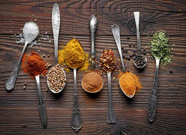 Various spices in silver spoons — Stock Photo, Image