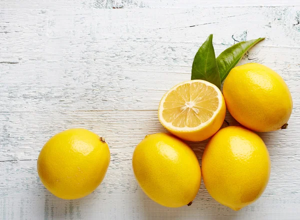 Свежие спелые лимоны на деревянном столе — стоковое фото