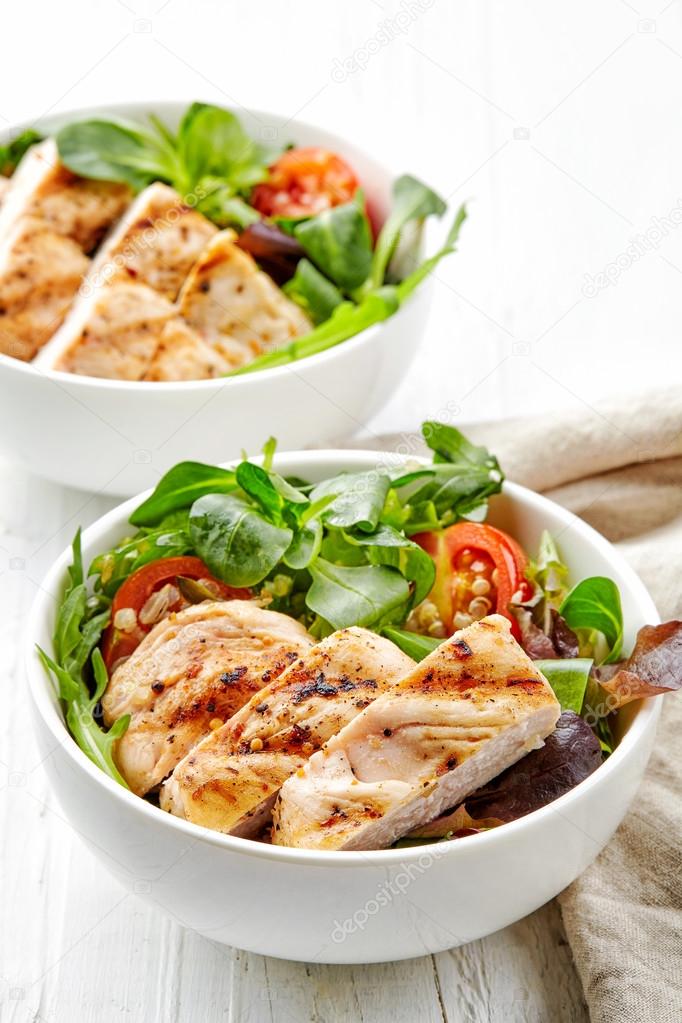 two bowls of salad with chicken