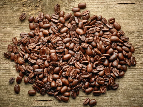 Grãos de café na mesa de madeira — Fotografia de Stock