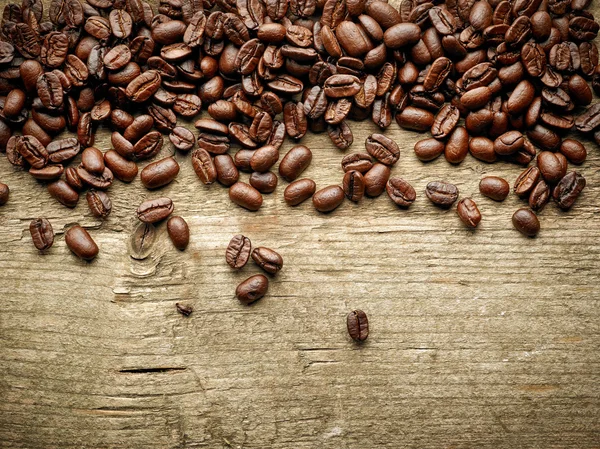 Granos de café sobre mesa de madera —  Fotos de Stock