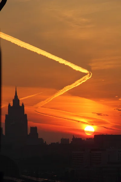 Trace of the plane. Dawn. City. — Stock Photo, Image