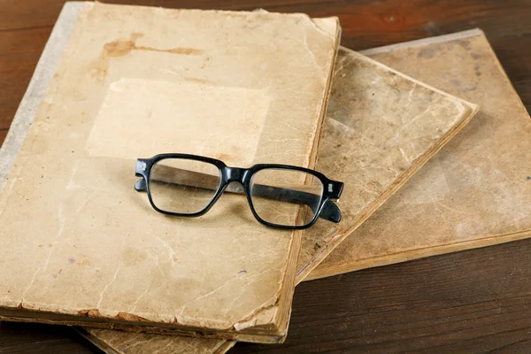 Livres anciens et verres sur une table en bois — Photo