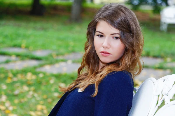 Portrait of a girl on a bench in the city park — Stock Photo, Image