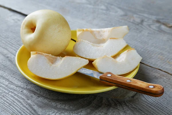Sliced yellow pear in a bowl on a rustic table — Stock Photo, Image