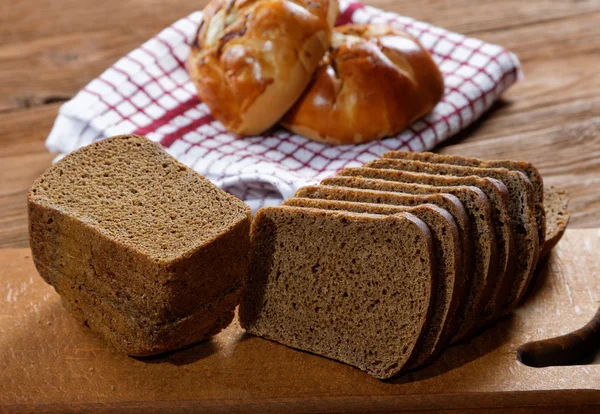 Mantar ve rustik masa üzerinde siyah ekmek buns — Stok fotoğraf