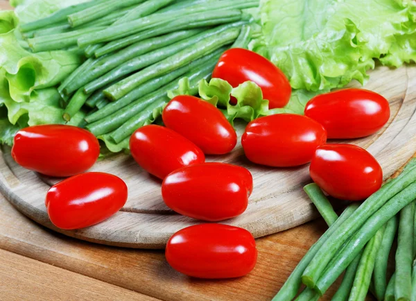 Small tomatoes and salad leaves close up — Stock Photo, Image