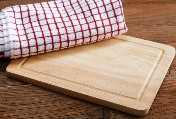 Kitchen towels and cutting board on a table — Stock Photo, Image