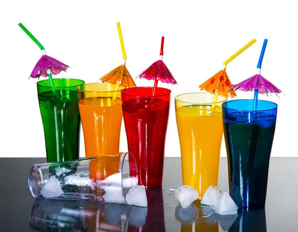 Colored glasses with cocktails and ice cubes on a white backgrou — Stock Photo, Image