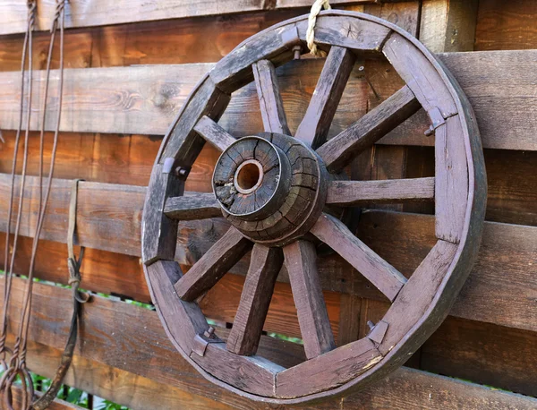Wooden wagon wheel on the fence Royalty Free Stock Photos