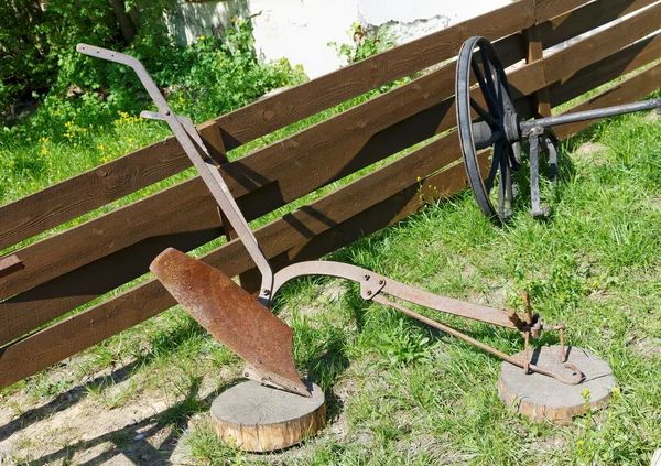 IJzeren ploeg op de houten hek zomerdag — Stockfoto