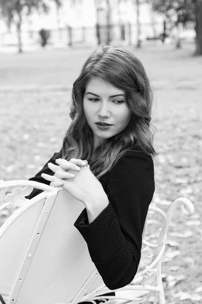 Portrait d'une fille sur un banc dans le parc municipal — Photo