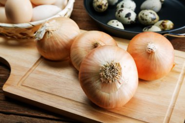 Natürmort soğan ve bıldırcın yumurtası mutfak masasında