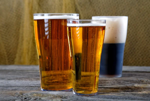 Okulary z ciemne i jasne piwa na stół wiejski — Zdjęcie stockowe