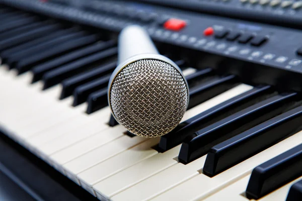 The microphone lies on the synthesizer keyboard — Stock Photo, Image